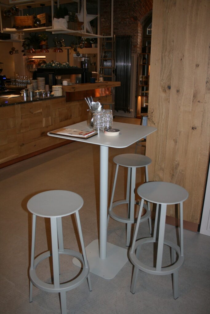 Modischer Tresen mit weißen Barhockern in einem modernen Café.
